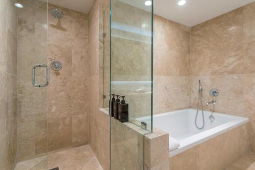 a bathroom with a shower with a tub and a shower stall at Oceanview Private Condo at 1 Hotel & Homes -915 in Miami Beach