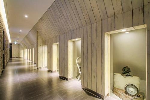 um corredor com paredes de madeira e um quarto com uma cadeira em Jamsil 2.4 Hotel em Seul
