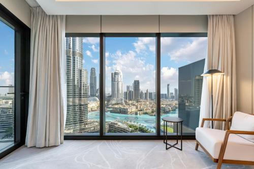 een kamer met een groot raam met uitzicht op de stad bij FAM Living - Burj Khalifa Bliss: Address Opera Modern 2BR in Dubai