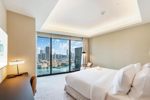 een slaapkamer met een groot wit bed en een groot raam bij FAM Living - Burj Khalifa Bliss: Address Opera Modern 2BR in Dubai