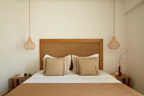 a bedroom with a bed with two pendant lights at Absolute Kiotari Resort in Kiotari
