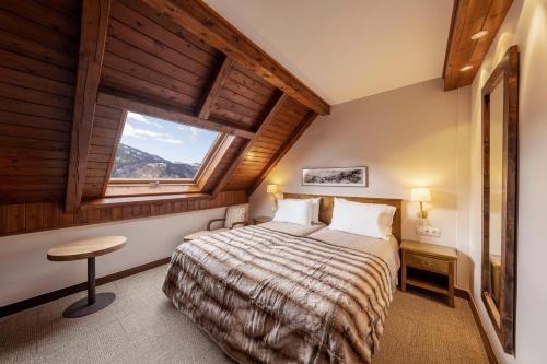 a bedroom with a bed in a room with a window at Eurostars La Pleta in Baqueira-Beret