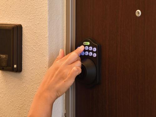 a person unlocking a door with their hand on it at Coldio Joint Home Naha in Naha