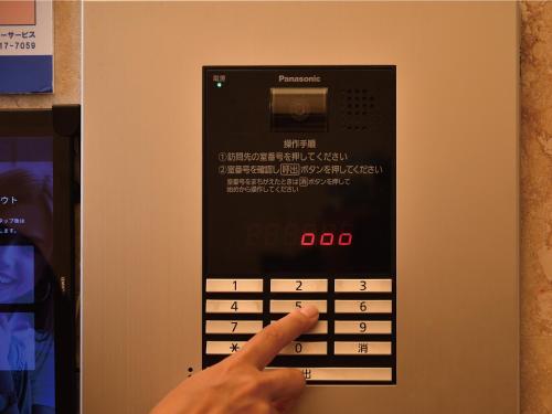 a person pointing at a phone with their index finger at Coldio Joint Home Naha in Naha