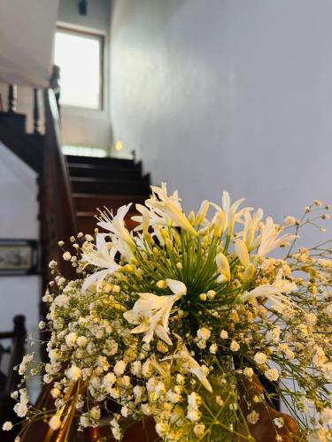 a bouquet of white flowers on a table next to a piano at Golden Town Hotel in Tangalle