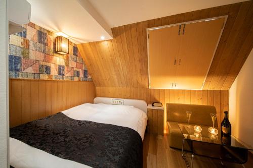 um pequeno quarto com uma cama e um armário em ホテル トランス 男塾ホテルグループ em Kobe