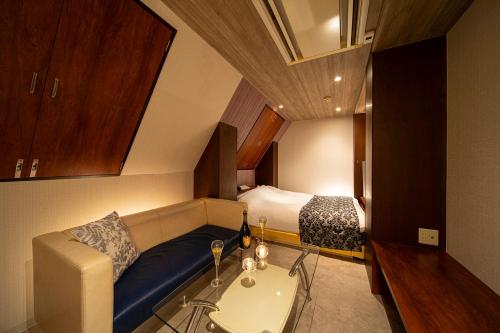 a small room with a couch and a bed at ホテル トランス 男塾ホテルグループ in Kobe