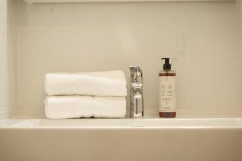 a bathroom sink with towels and a bottle of soap at Royal Square View Residence in Prague