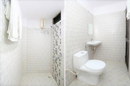 a white bathroom with a toilet and a shower at JAZEERA RESORT in Port Blair