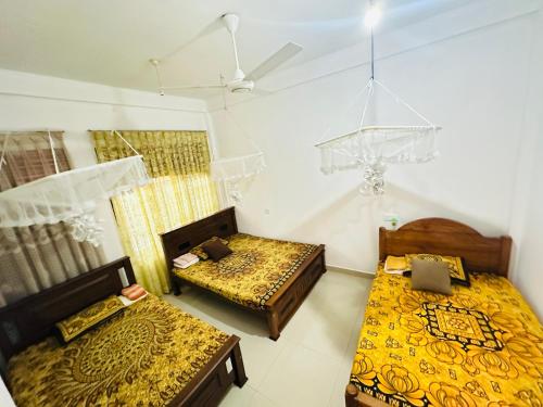 una camera con due letti e un soffitto di Golden Town Hostel a Tangalle