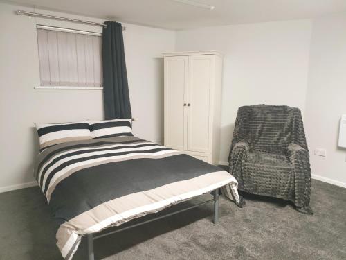 una camera con letto e sedia di Local to Russells Hall Hospital a Brierley Hill