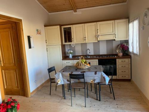 a kitchen with a table and chairs and a kitchen with white cabinets at La Depandance in Marano di Napoli