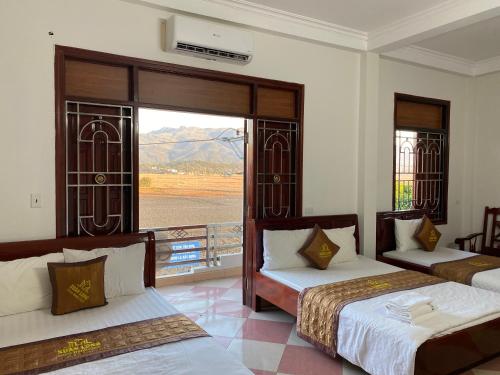1 dormitorio con 2 camas y ventana con vistas en Nhà nghỉ Xuân Long - Xuan Long gues - Tỉnh Điện Biên en Bản Him Lom