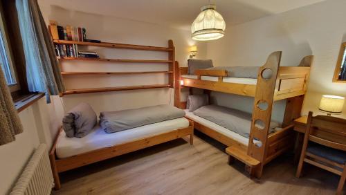 ein Zimmer mit zwei Etagenbetten und einem Schreibtisch in der Unterkunft Chesa Bellaval, Haus Chamuotsch 3 1 2-Zimmerwohnung in Silvaplana