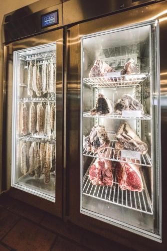 a refrigerator filled with meat and meats on racks at Due Ponti Village in Cesenatico