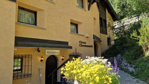 a yellow building with flowers in front of it at Chesa Bellaval, Haus Chamuotsch 3 1 2-Zimmerwohnung in Silvaplana