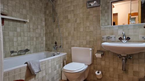 y baño con aseo, lavabo y bañera. en Chesa Bellaval, Haus Rizza 1 1 2-Zimmerwohnung, en Silvaplana