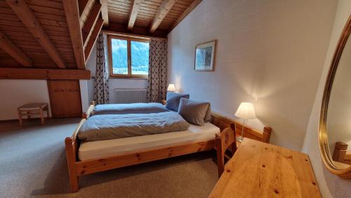 シルヴァプラーナにあるChesa Bellaval, Haus Rizza 3 1 2 Zimmerwohnungのベッドとテーブルと鏡のある寝室