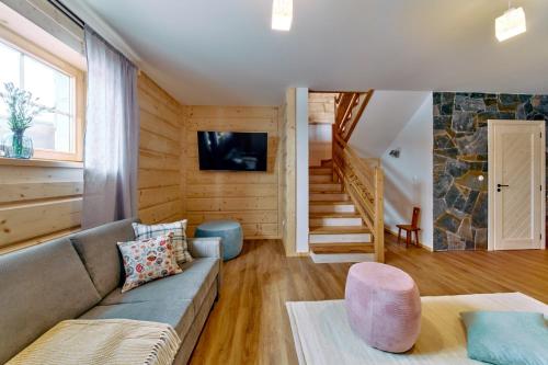 a living room with a couch and a staircase at Marusina Chalets in Szaflary