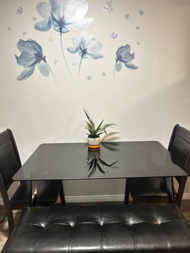 a table with a plant on a wall with blue flowers at Comfortable room B in Kitchener
