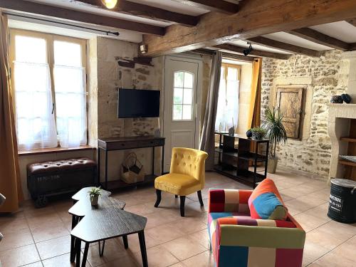 un salon avec un canapé et une télévision dans l'établissement Gîte La Cassine, à Taillant