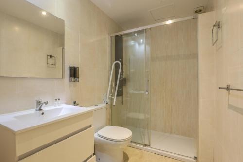 uma casa de banho com um chuveiro, um WC e um lavatório. em Patio de la Cartuja - 4 pax em Sevilha
