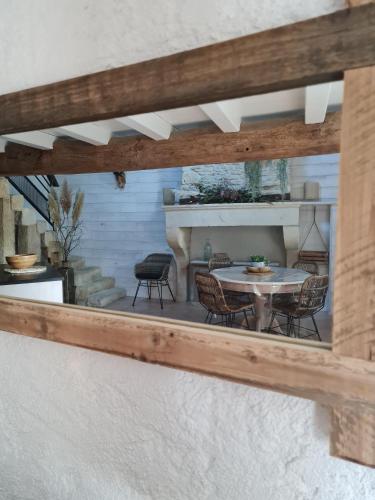 a reflection of a table and chairs in a mirror at Gite La baragane in Taillant
