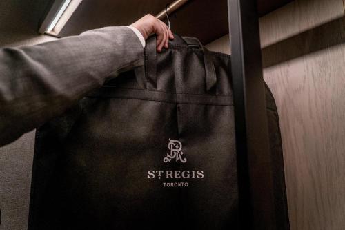 a person is holding a black tote bag at The St. Regis Toronto in Toronto