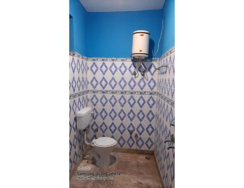 uma casa de banho com um WC e uma parede azul em Hotel Abhi Jawalamukhi, Himachal Pradesh em Jawāla Mukhi