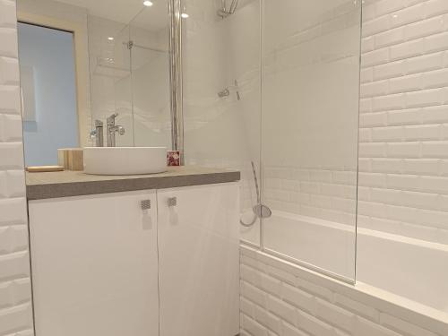 uma casa de banho branca com um lavatório e um chuveiro em Ravissant T2 vue mer et massif - Les Clés de L´Estérel em Théoule-sur-Mer