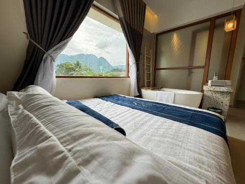 Un dormitorio con una cama grande y una ventana en Muzi Boutique Hotel en Ipoh