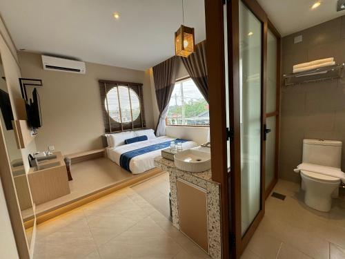 a bedroom with a bed and a toilet and a sink at Muzi Boutique Hotel in Ipoh