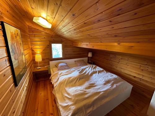 een slaapkamer met een bed in een houten hut bij Porkka COSY & QUIET chalet 8 pers in Vex