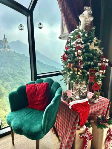 a christmas tree in a room with a chair at Venus Hotel Tam Đảo in Tam Ðảo