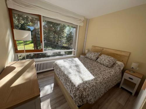 ein Schlafzimmer mit einem Bett und einem großen Fenster in der Unterkunft Apartamento Masella pie de pistas. Ideal familias in Alp
