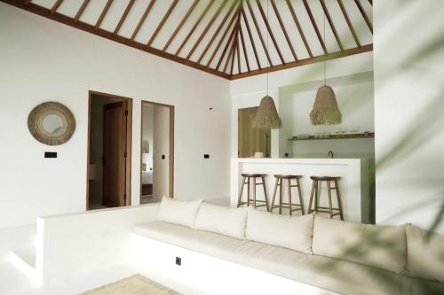 uma sala de estar com um sofá e uma cozinha em VILLA ROSADO - Canggu's Hidden Gem: beautiful boutique Villa em Canggu