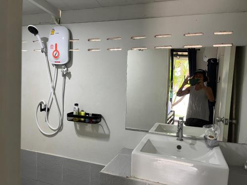 a person taking a picture in a bathroom mirror at Namthip Homebeach in Ban Tai