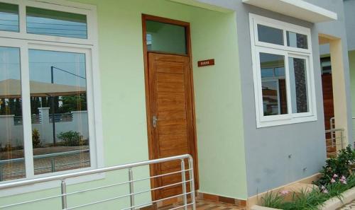a house with a wooden door and a balcony at Hamasa Apartments in Dodoma