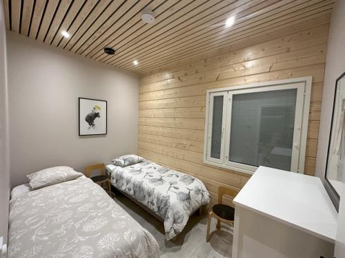 a bedroom with two beds and a window at Lakeside Lodge Norvis in Rovaniemi
