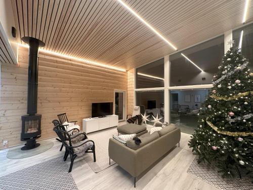 ein Wohnzimmer mit einem Weihnachtsbaum darin in der Unterkunft Lakeside Lodge Norvis in Rovaniemi