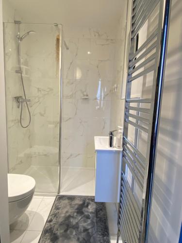 uma casa de banho com um chuveiro, um WC e um lavatório. em Modern Home Near Edinburgh City em Bonnyrigg
