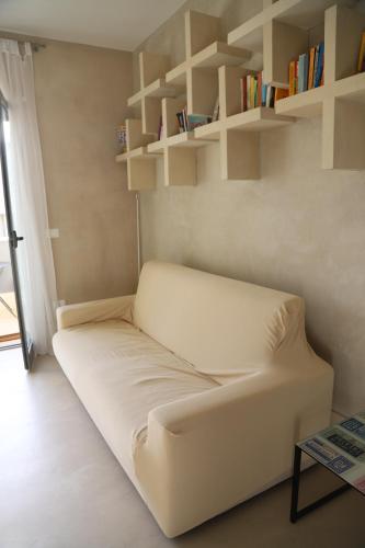 a white couch in a room with shelves at Otranto casevacanza Elena in Otranto