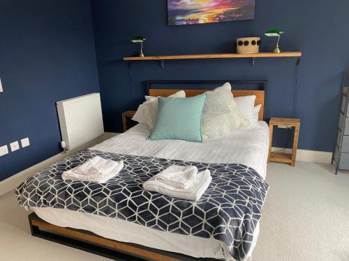 a bedroom with a bed with two towels on it at Modern Home Near Edinburgh City in Bonnyrigg