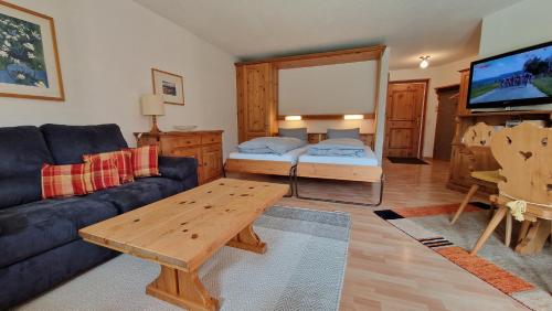 ein Wohnzimmer mit einem Sofa und einem Tisch in der Unterkunft Chesa Bellaval, Haus Leivra 2 1 2-Zimmerwohnung in Silvaplana