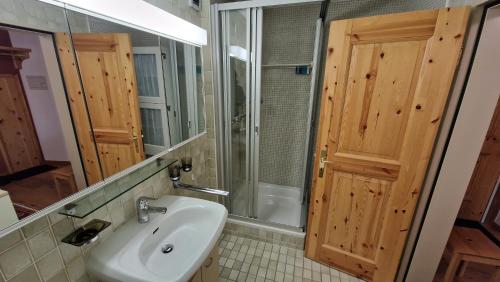 a bathroom with a sink and a shower and a mirror at Chesa Bellaval, Haus la Vuolp 2,5-Zimmerwohnung in Silvaplana