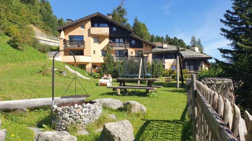 a large house with a playground in front of it at Chesa Bellaval, Haus Leivra 2 1 2-Zimmerwohnung in Silvaplana