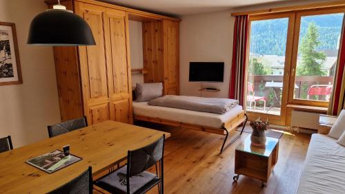 a living room with a bed and a table at Chesa Bellaval, Haus Leivra 2 1 2-Zimmerwohnung in Silvaplana