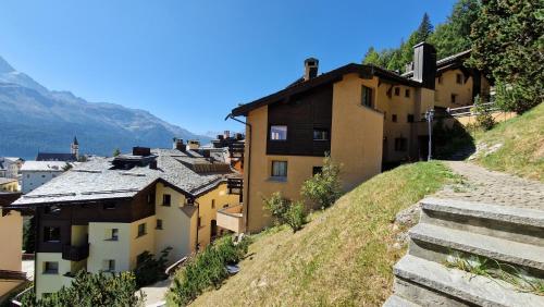a small town on a hill with buildings at Chesa Bellaval, Haus la Vuolp 2 1 2 Zimmerwohnung in Silvaplana