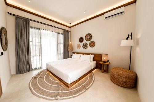 een slaapkamer met een bed en een groot raam bij Hijau Villa by EVDEkimi Ubud in Ubud