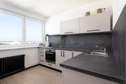 a kitchen with white cabinets and a black counter top at Hotel Koruna in Opava